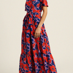 Woman wearing a red and blue floral dress on a beige background