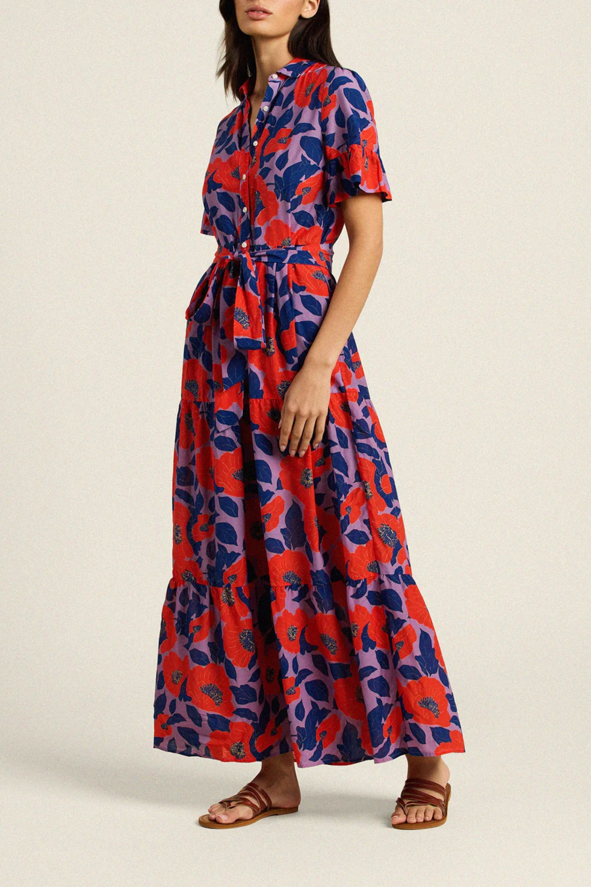 Woman wearing a red and blue floral dress on a beige background