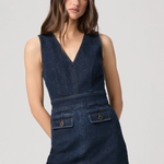 Woman wearing a denim dress against a plain background