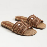 Pair of brown sandals with woven design on a white background