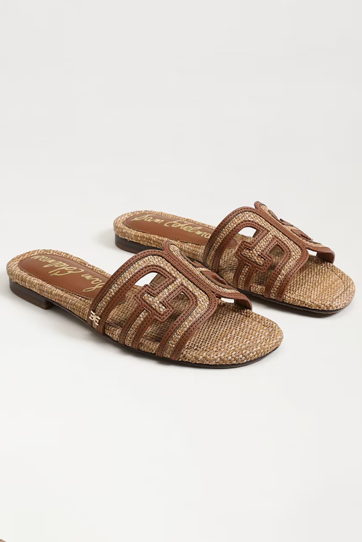 Pair of brown sandals with woven design on a white background