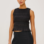 woman in black smocked sleeveless top on white background 