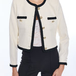 woman in white jacket with black trim on white background 