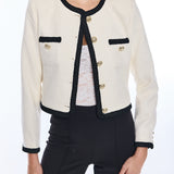 woman in white jacket with black trim on white background 