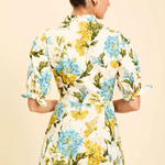 Woman wearing a floral dress with a beige background