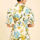 Woman wearing a floral dress with a beige background