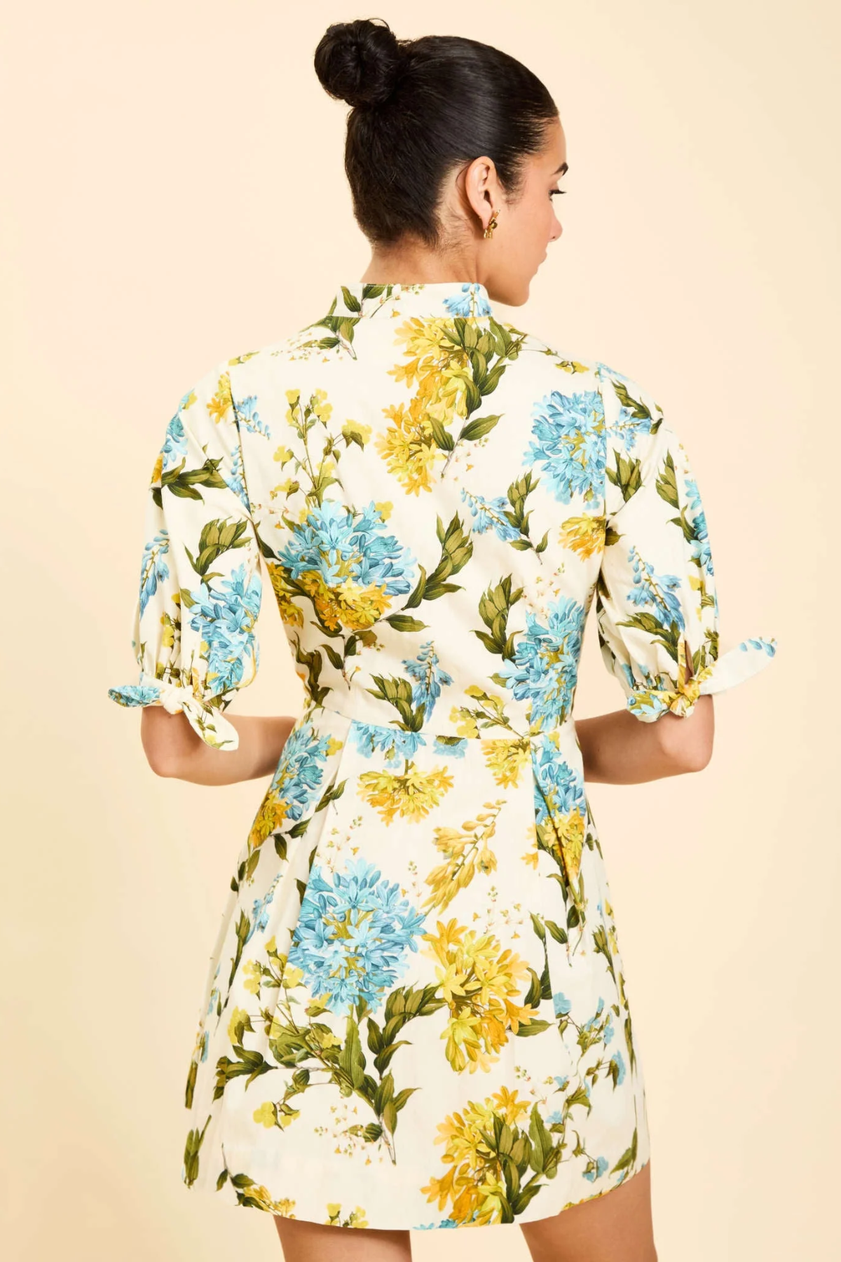 Woman wearing a floral dress with a beige background