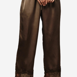 A person wearing wide-leg brown satin pants with a lace hem, paired with black pointed shoes against a plain light gray background.