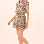 Woman wearing a patterned dress on a beige background