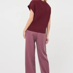 A woman shown from the back wearing a short-sleeve maroon top and mauve wide-leg pinstripe trousers against a plain white studio background.