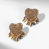 Heart-shaped earrings with spike details on a light gray background