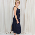 Indigo midi dress with a sweetheart neckline, corset-inspired seams, and a belted waist