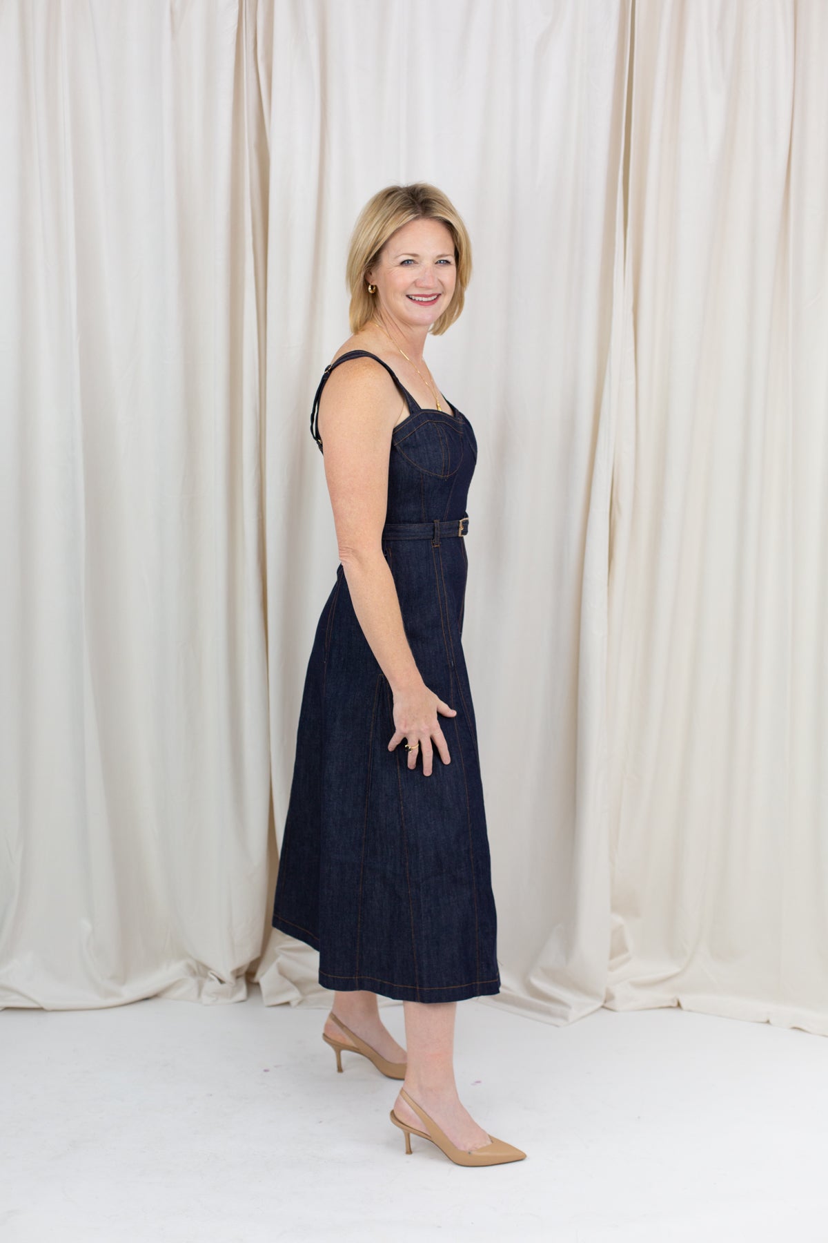 Indigo midi dress with a sweetheart neckline, corset-inspired seams, and a belted waist