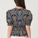 Woman wearing a blue and yellow patterned top on a white background
