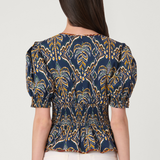 Woman wearing a blue and yellow patterned top on a white background