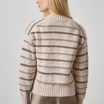 Woman wearing a striped sweater against a plain background