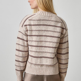 Woman wearing a striped sweater against a plain background