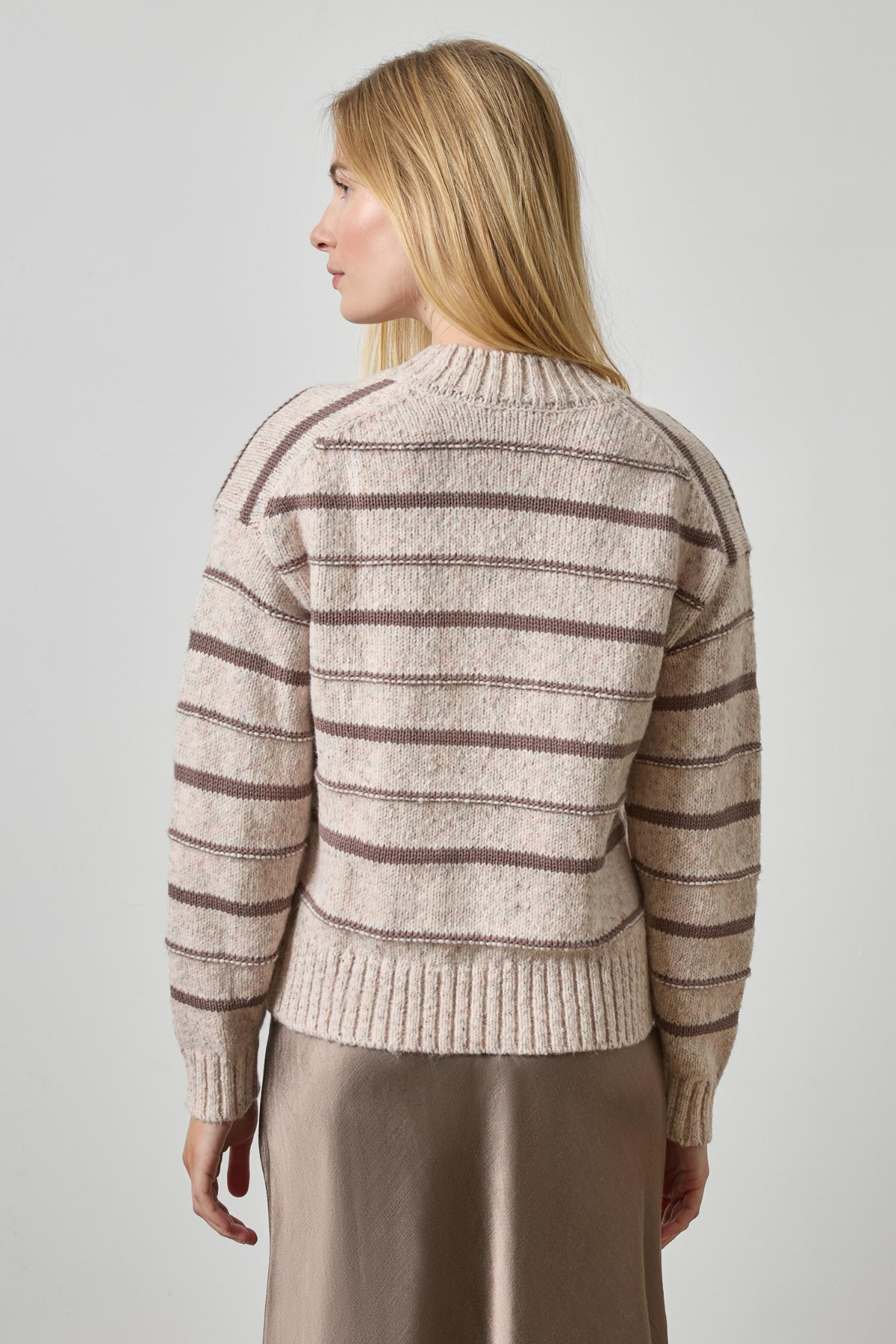 Woman wearing a striped sweater against a plain background