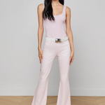 woman in pink top and jeans inside 