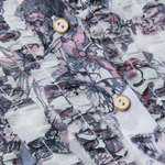 Close-up of a shirt with butterfly pattern and gold buttons