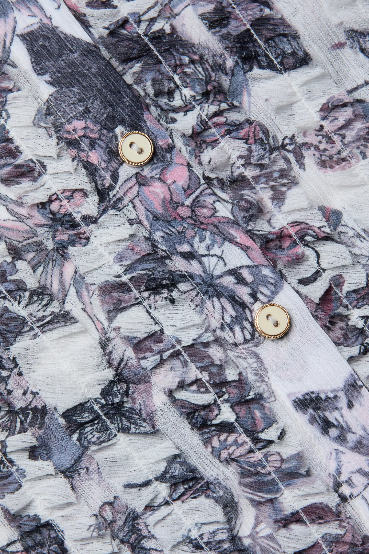 Close-up of a shirt with butterfly pattern and gold buttons