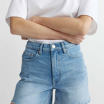 Person wearing light blue denim shorts and a white t-shirt on a plain background