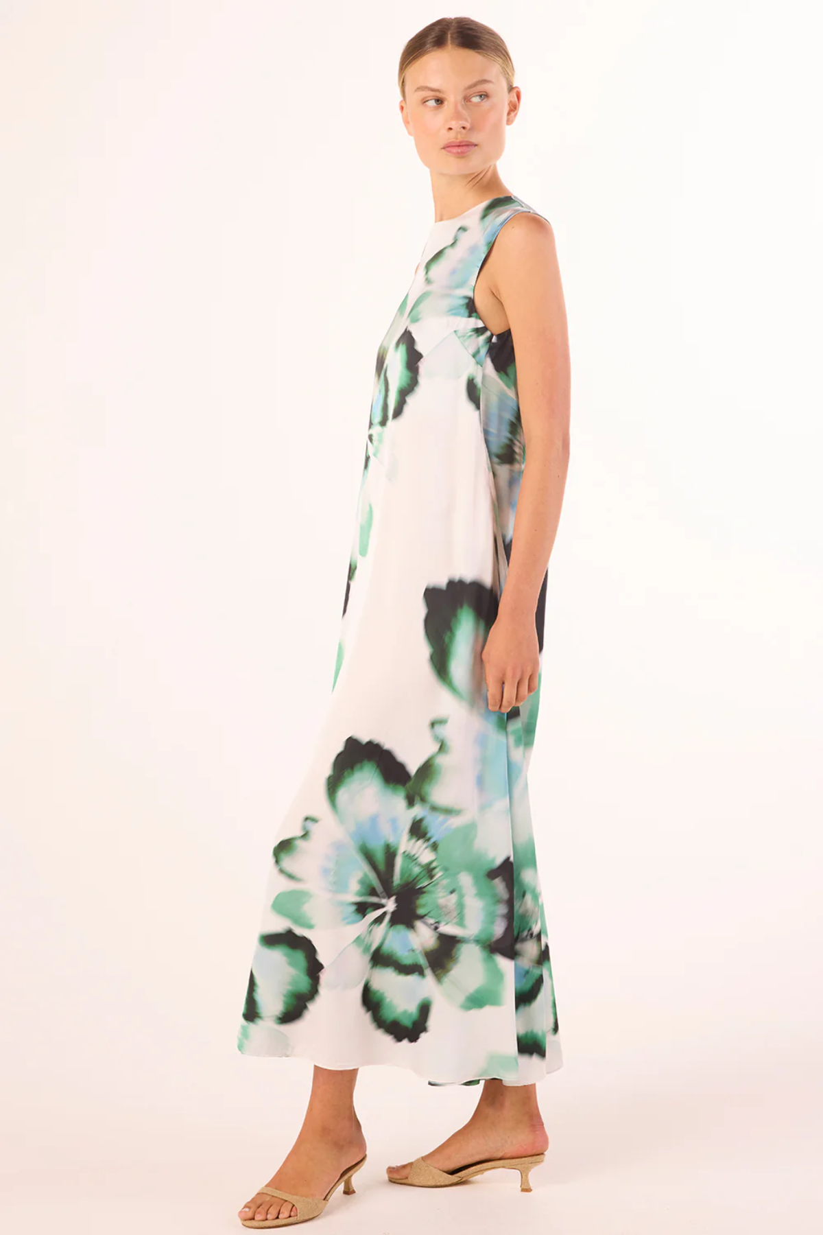 side view of woman in floral printed dress on white background 