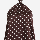 A halter-neck top in dark brown with a white polka dot pattern, displayed against a light gray background.