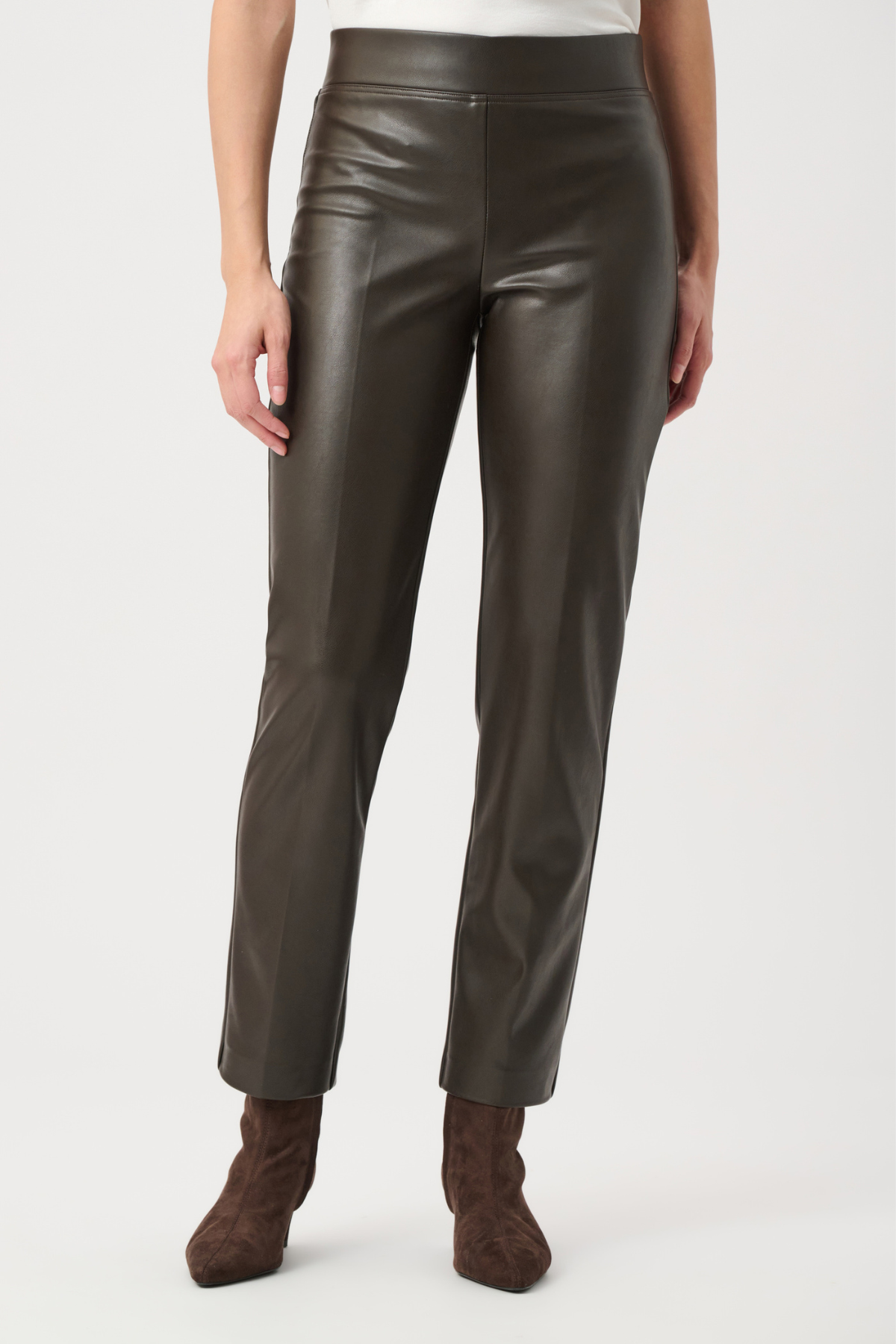 Person wearing dark brown leather pants on a white background