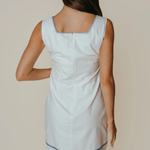 Woman wearing a light blue dress with a white background
