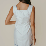 Woman wearing a light blue dress with a white background