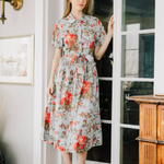 Woman in a floral dress standing in a doorway