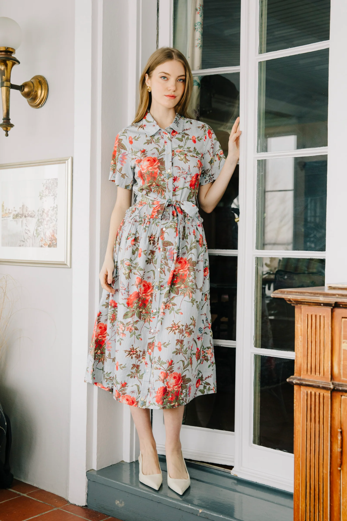 Woman in a floral dress standing in a doorway