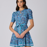 Woman wearing a blue patterned dress on a gray background