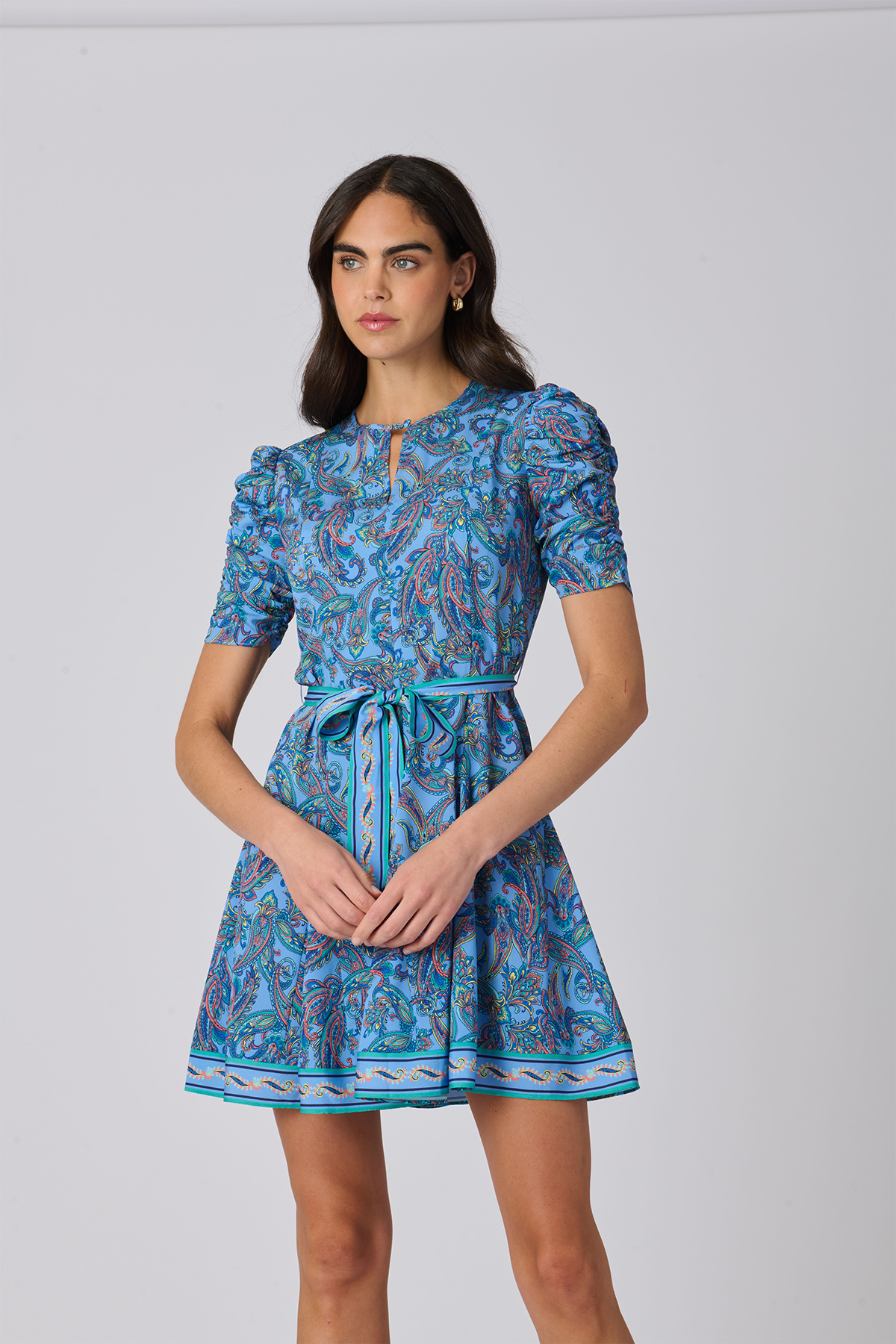 Woman wearing a blue patterned dress on a gray background