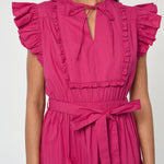 Woman wearing a vibrant pink sleeveless midi dress with soft tailoring and fluid drape.