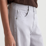 Close-up of a person wearing light gray wide-leg jeans with a brown top, showing the back pocket and waistband area against a plain light background.