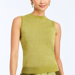 A woman modeling a sleeveless knit top in olive green with matching satin pants, holding a brown clutch against a light gray studio background.
