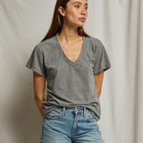 Woman wearing a gray t-shirt and blue jeans against a plain background