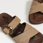 Pair of brown sandals with decorative straps on a white background
