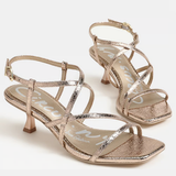 Pair of rose gold strappy high-heeled sandals on a white background