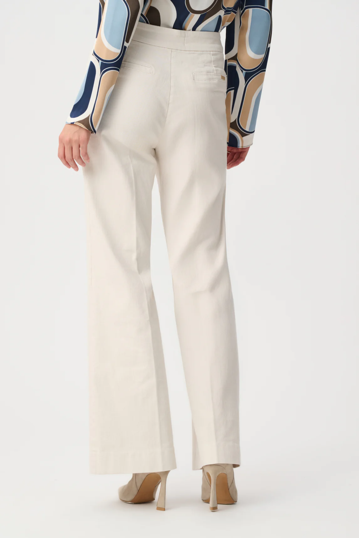 Model wearing white high-rise stretch denim wide-leg jeans with a full-length silhouette.