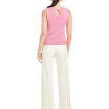 Woman wearing a pink sleeveless top and white pants on a white background
