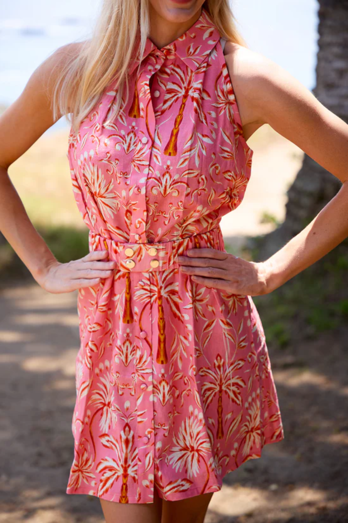 Woman wearing a pink floral dress with a blurred natural background