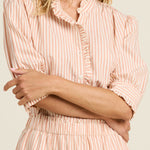 Woman wearing a pink and white striped blouse with a plain background