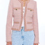 woman in blush pink tweed jacket on white background 