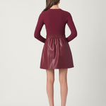 Woman wearing a maroon dress with a plain background