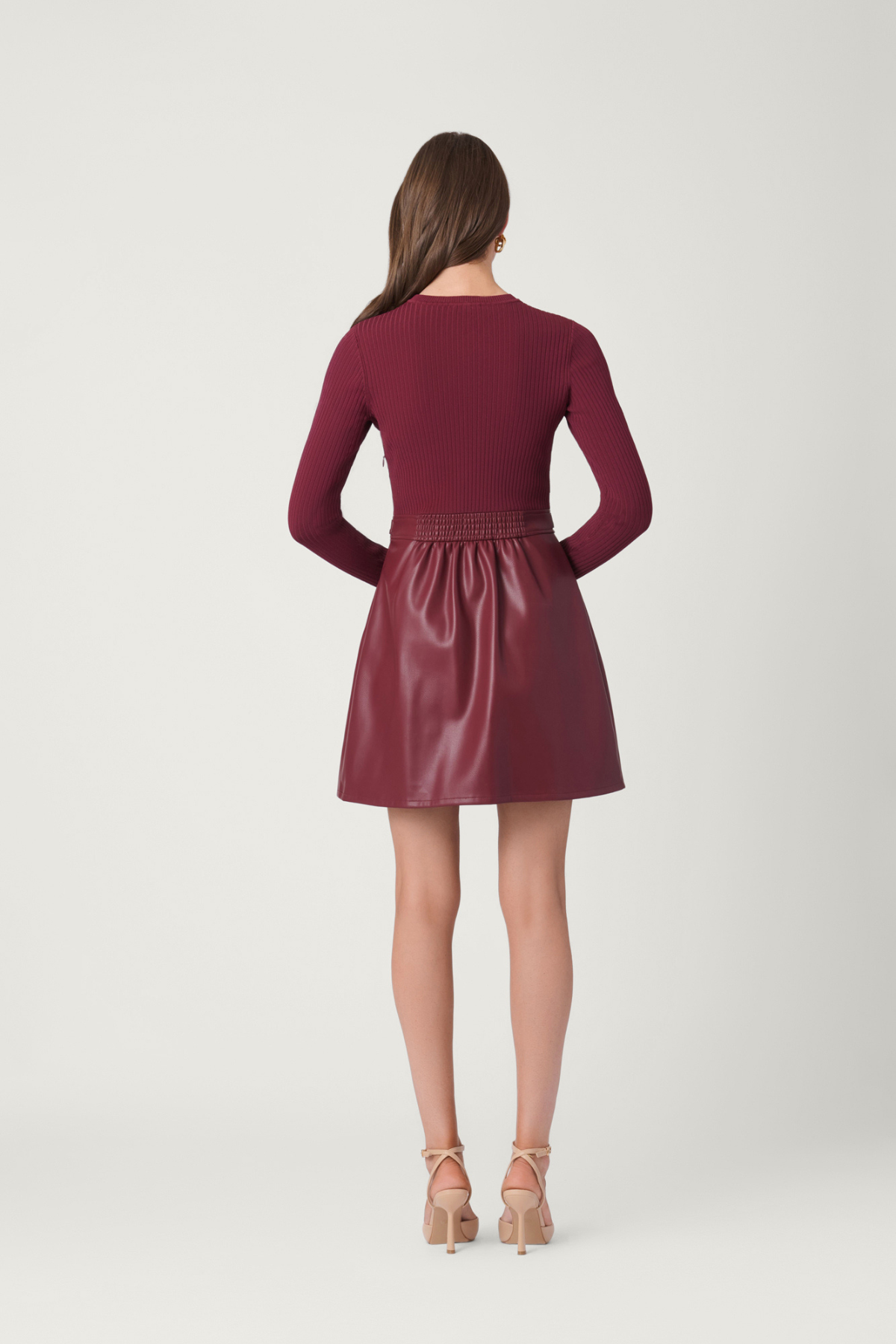Woman wearing a maroon dress with a plain background
