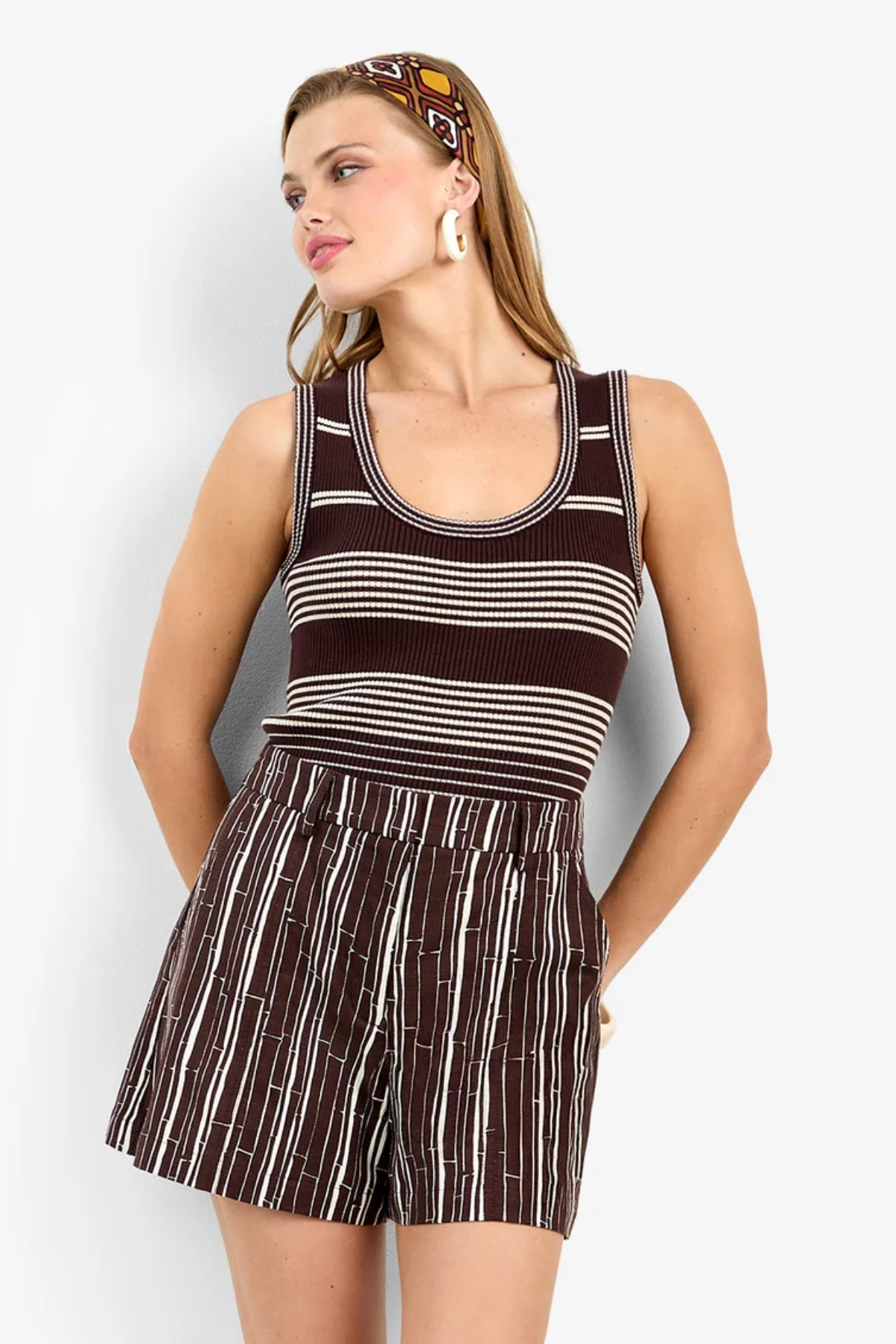 Model wearing a sleeveless fitted tank top with a classic neckline and streamlined silhouette.