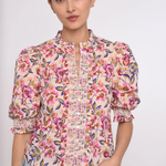 Woman wearing a floral blouse with puffed sleeves on a white background